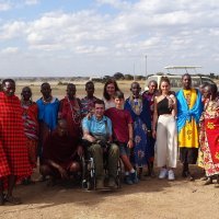 Usuario de silla de ruedas posando con su familia y guerreros Masai en Kenia