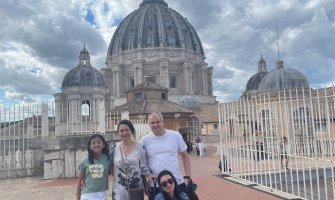 Una familia de viaje por Europa con la cúpula de Sacre Coeur de fondo