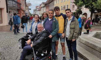 Una familia en una calle de Berlin. Una de las personas utiliza un scooter para la movilidad