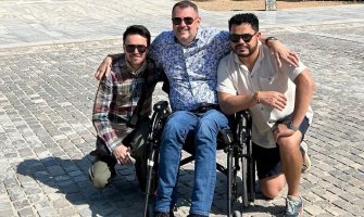 Una persona usuaria de silla de ruedas con dos amigos en Atenas