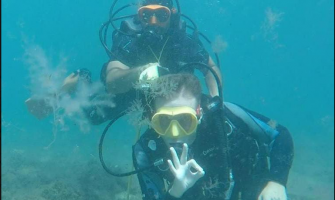 La foto muestra a una persona con discapacidad realizando buceo adaptado junto a su pareja