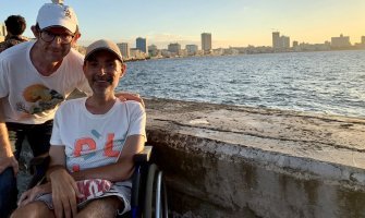 Dos personas, una de ellas usuaria de silla de ruedas, en el Malecón, en Cuba