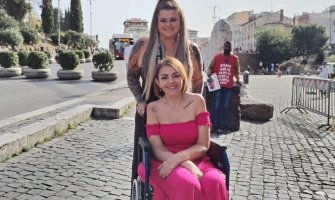 Dos amigas, una de ellas usuaria de silla de ruedas, en una calle de Roma