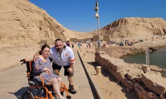 Una pareja en un viaje accesible a Egipto. Ella es usuaria de silla de ruedas. Al fondo se ven monumentos de piedra