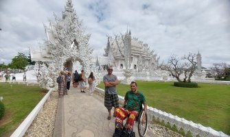 Usuario de silla de ruedas frente a un Templo Budista en Tailandia